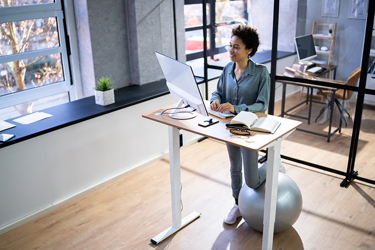 Lady using adjustable desk standing while working