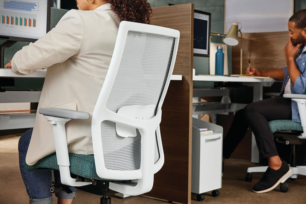 Closeup view of person sitting in ergonomic office chair.